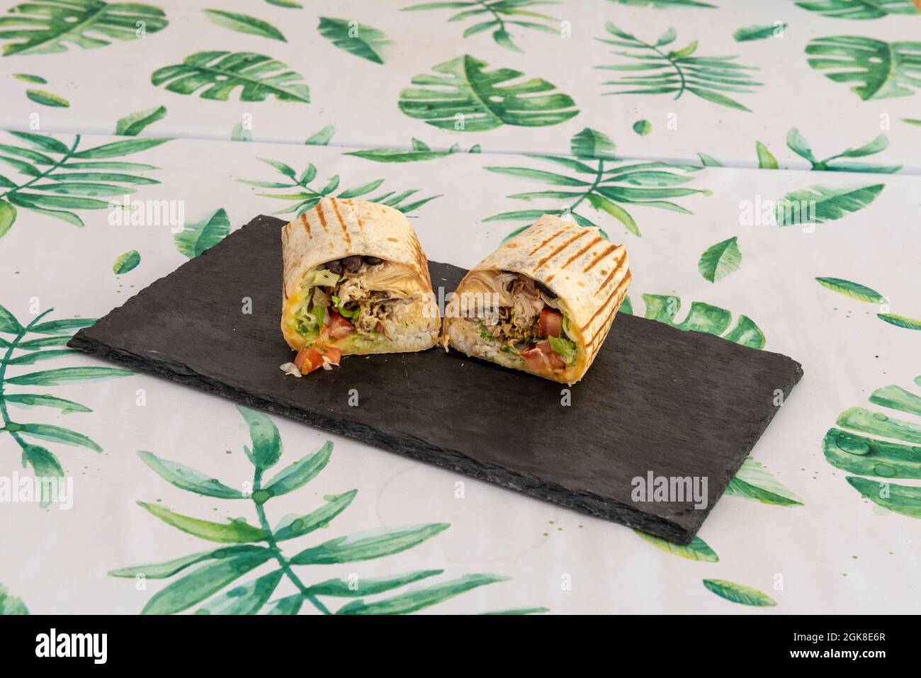 Classic Mexican burrito with pulled chicken meat, black beans, pico de