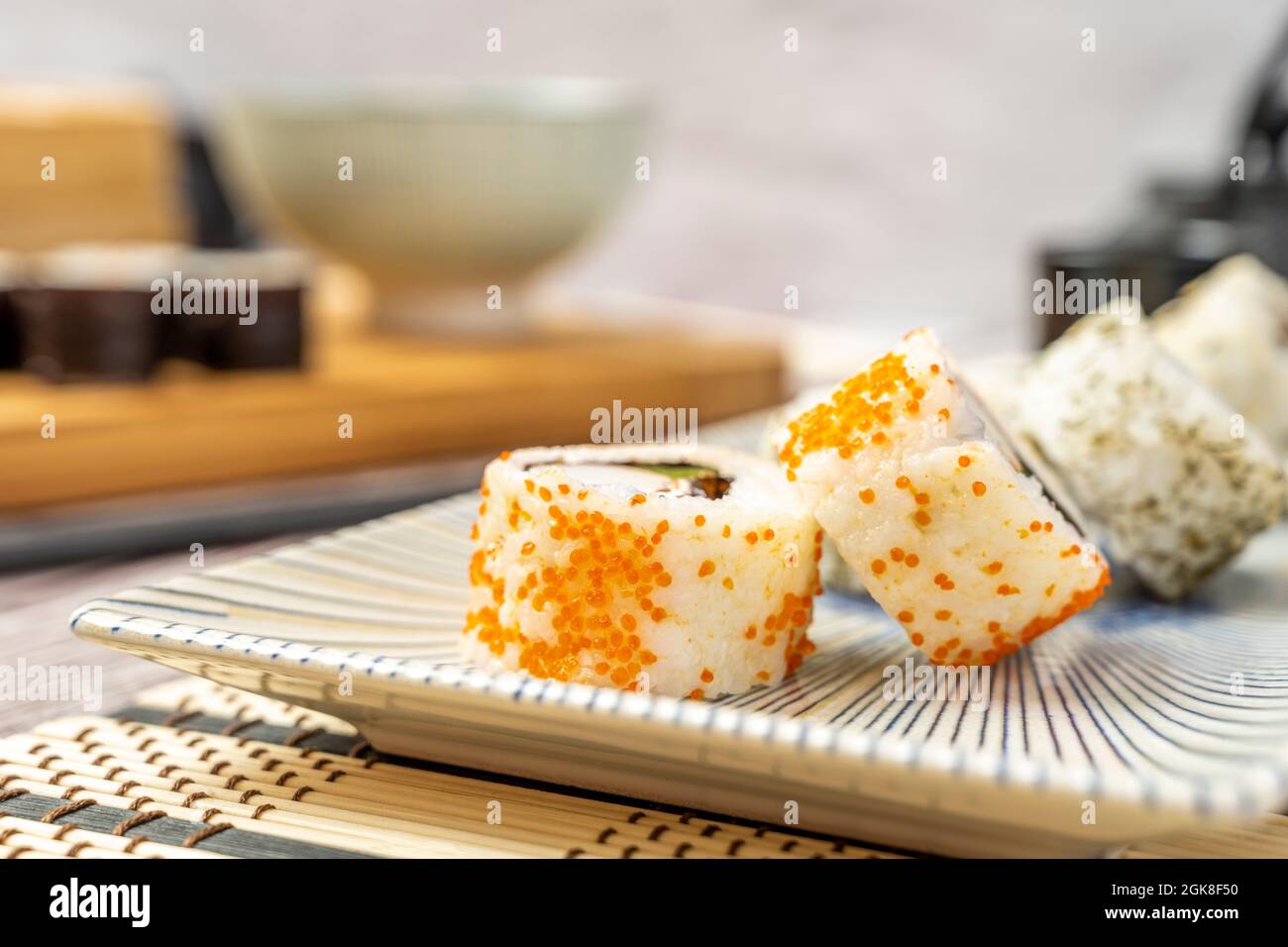 Close-up of uramaki california roll with orange fish roe on a grated plate Stock Photo