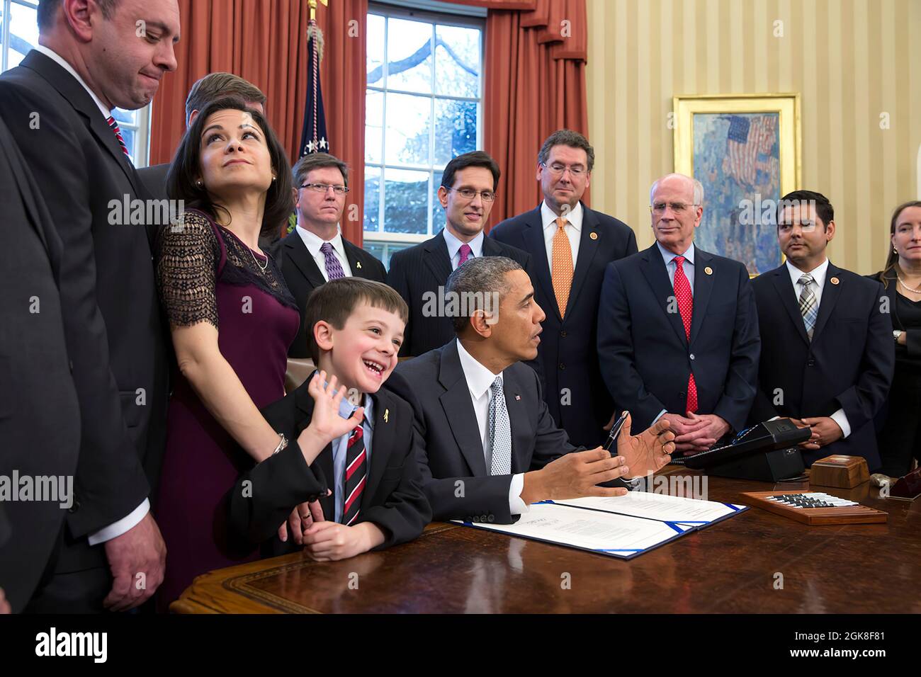 Mark and Ellyn Miller and their son Jacob react before President Barack Obama signs H.R. 2019, the Gabriella Miller Kids First Research Act, in the Oval Office, April 3, 2014. The law ends taxpayer contributions to the Presidential Election Campaign Fund and diverts the money in that fund to pay for research into pediatric cancer through the National Institutes of Health (NIH). (Official White House Photo by Pete Souza) This official White House photograph is being made available only for publication by news organizations and/or for personal use printing by the subject(s) of the photograph. Th Stock Photo