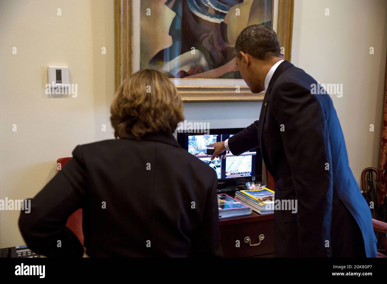 President Barack Obama watches television coverage of the Boston Marathon bombings with Lisa Monaco, Assistant to the President for Homeland Security and Counterterrorism, in the Outer Oval Office, April 15, 2013. (Official White House Photo by Pete Souza) This official White House photograph is being made available only for publication by news organizations and/or for personal use printing by the subject(s) of the photograph. The photograph may not be manipulated in any way and may not be used in commercial or political materials, advertisements, emails, products, promotions that in any way s Stock Photo