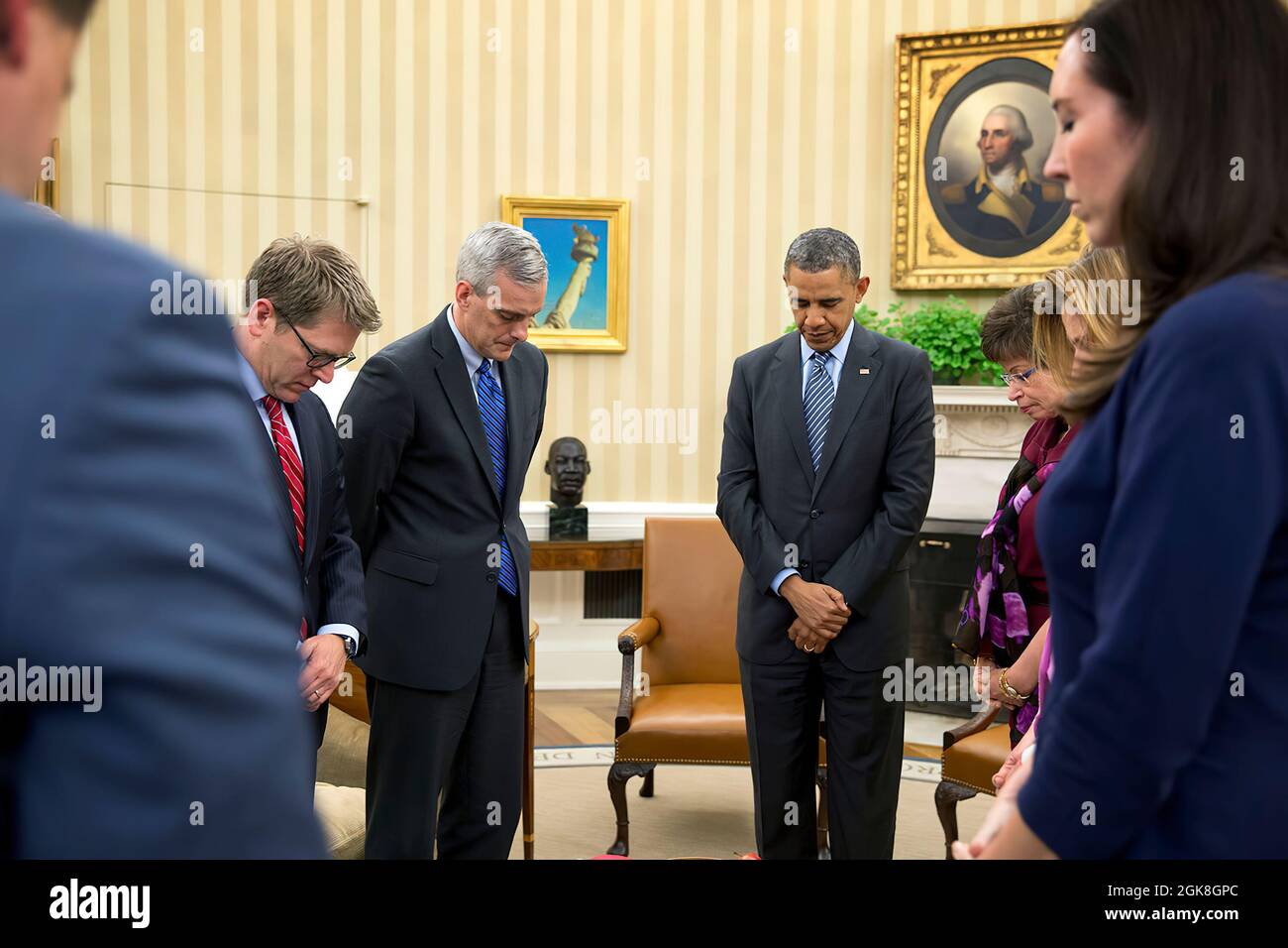 President Barack Obama observes a moment of silence during his meeting with senior advisors in the Oval Office at 2:49 P.M., April 15, 2014, to mark the one-year anniversary of the Boston Marathon bombings. Pictured from left, are Senior Advisor Dan Pfeiffer, Press Secretary Jay Carney, Chief of Staff Denis McDonough, Senior Advisor Valerie Jarrett, Communications Director Jennifer Palmieri, and Katie Beirne Fallon, Director of Legislative Affairs. (Official White House Photo by Pete Souza)  President Barack Obama observes a moment of silence during his meeting with senior advisors in the Oval Stock Photo