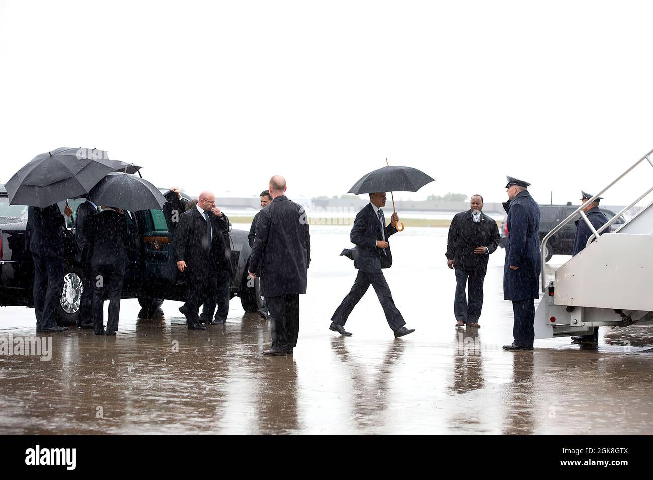 President Barack Obama carries an umbrella to board Air Force One at Charlotte Douglas International Airport prior to departure from Charlotte, N.C., April 15, 2015. (Official White House Photo by Amanda Lucidon) This official White House photograph is being made available only for publication by news organizations and/or for personal use printing by the subject(s) of the photograph. The photograph may not be manipulated in any way and may not be used in commercial or political materials, advertisements, emails, products, promotions that in any way suggests approval or endorsement of the Presi Stock Photo