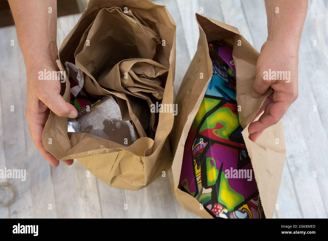 Female hands are wrapping paper bags from delivered food. Waste paper