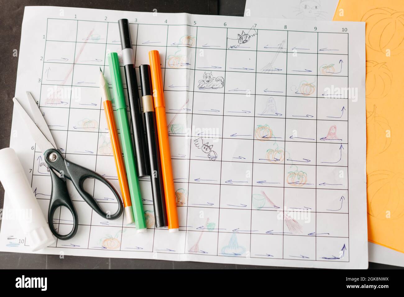 Creating Halloween-themed board game. Sheets of colored paper, sketches ...