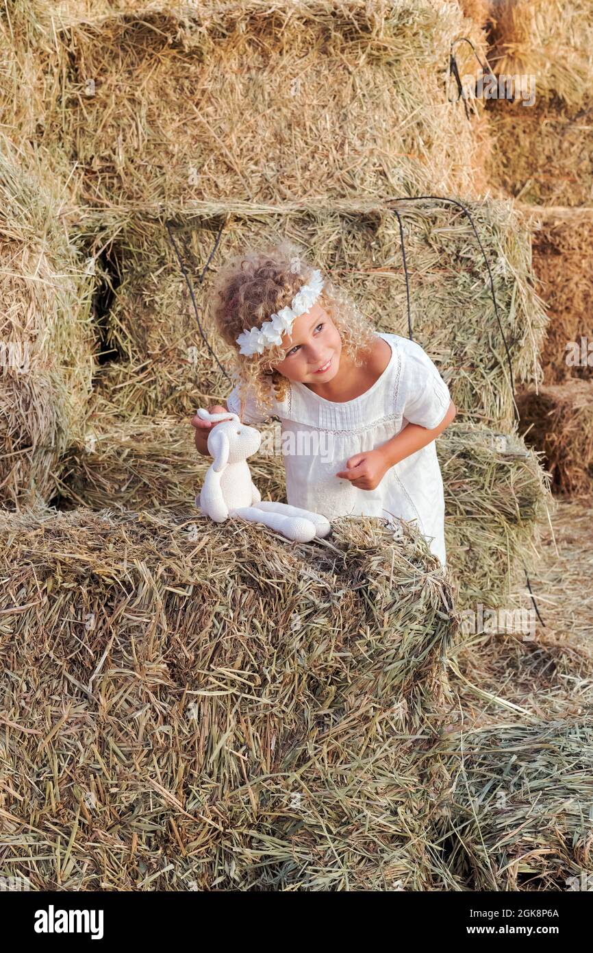 Little girl with a stuffed animal in a haystack Stock Photo - Alamy