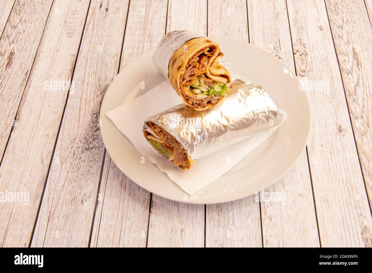 Lamb meat durum with lettuce and tomato rolled with aluminum foil cooked in a kebab restaurant Stock Photo