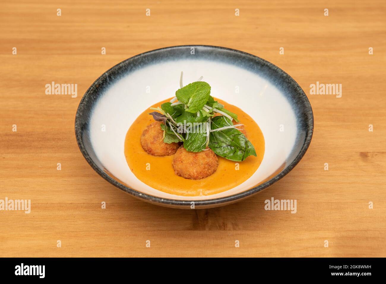 Spicy Red Curry Bowl with Peppermint, Spinach, Bean Sprouts and Breaded Pork Balls Stock Photo