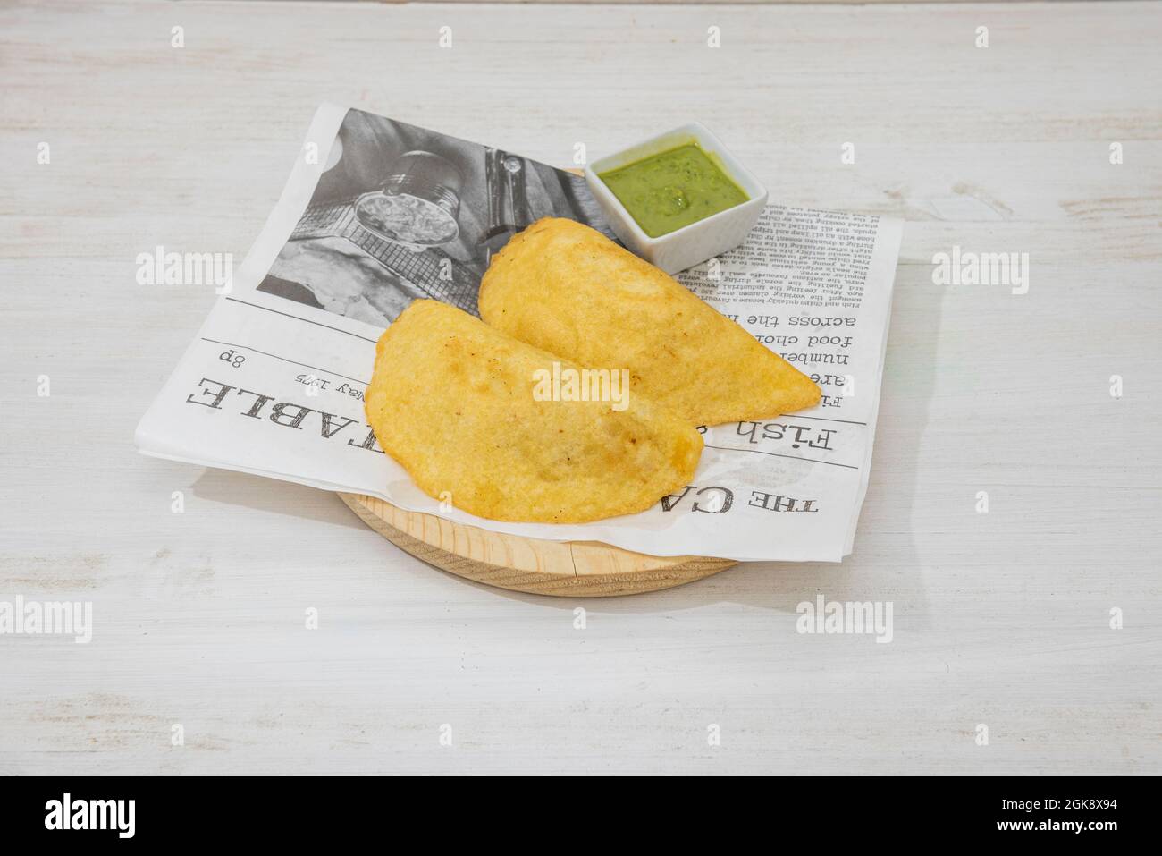 Colombian cornmeal empanadas with dip sauce on wood plate Stock Photo