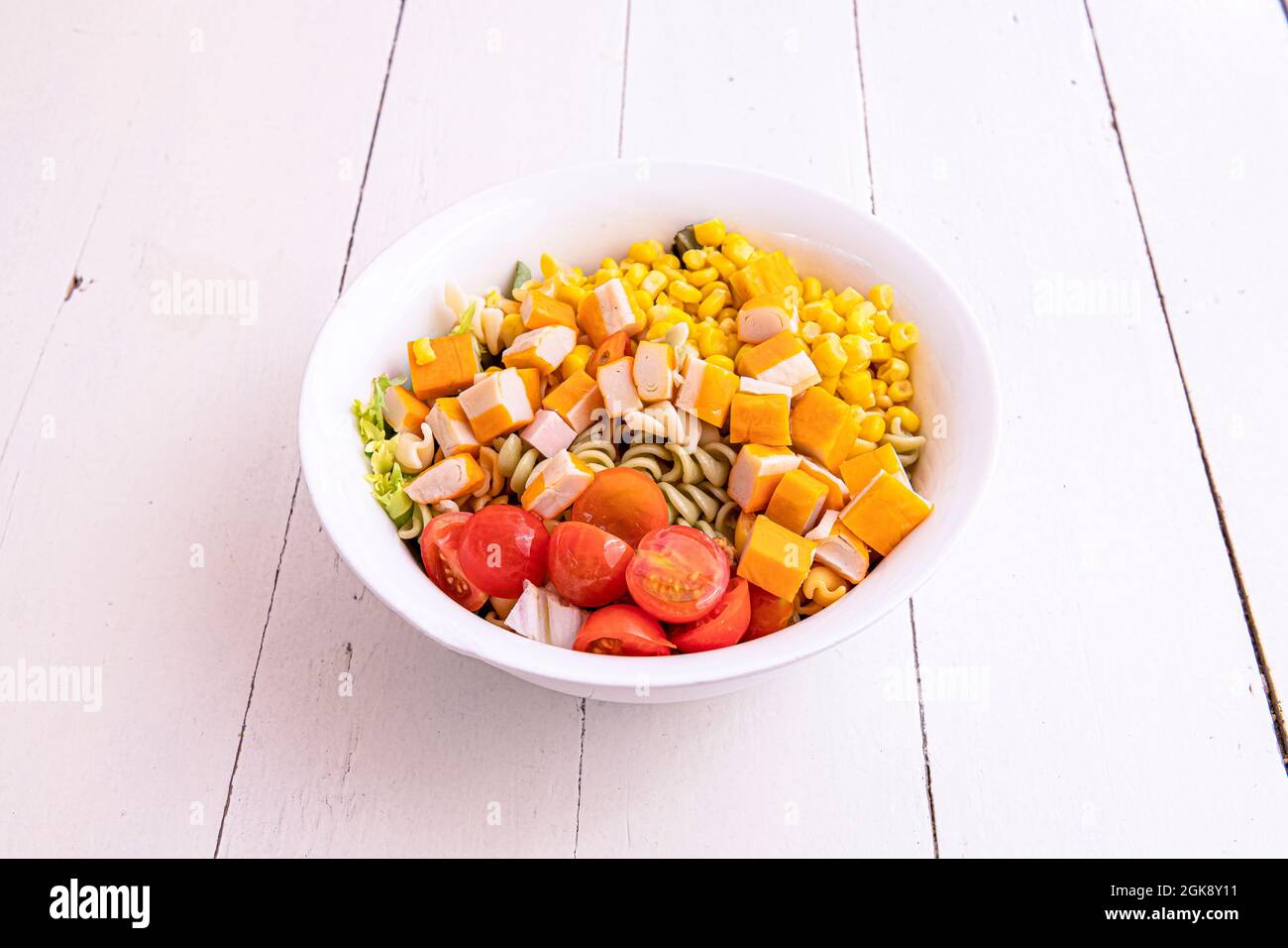 Pasta salad with cherry tomatoes, chopped surimi, iceberg lettuce and