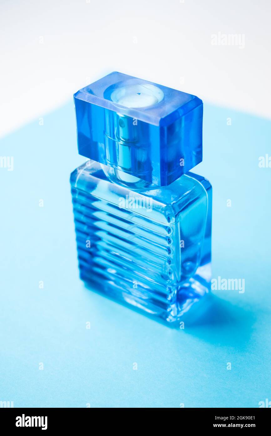 Blue male perfume bottle isolated on the light blue surface Stock Photo