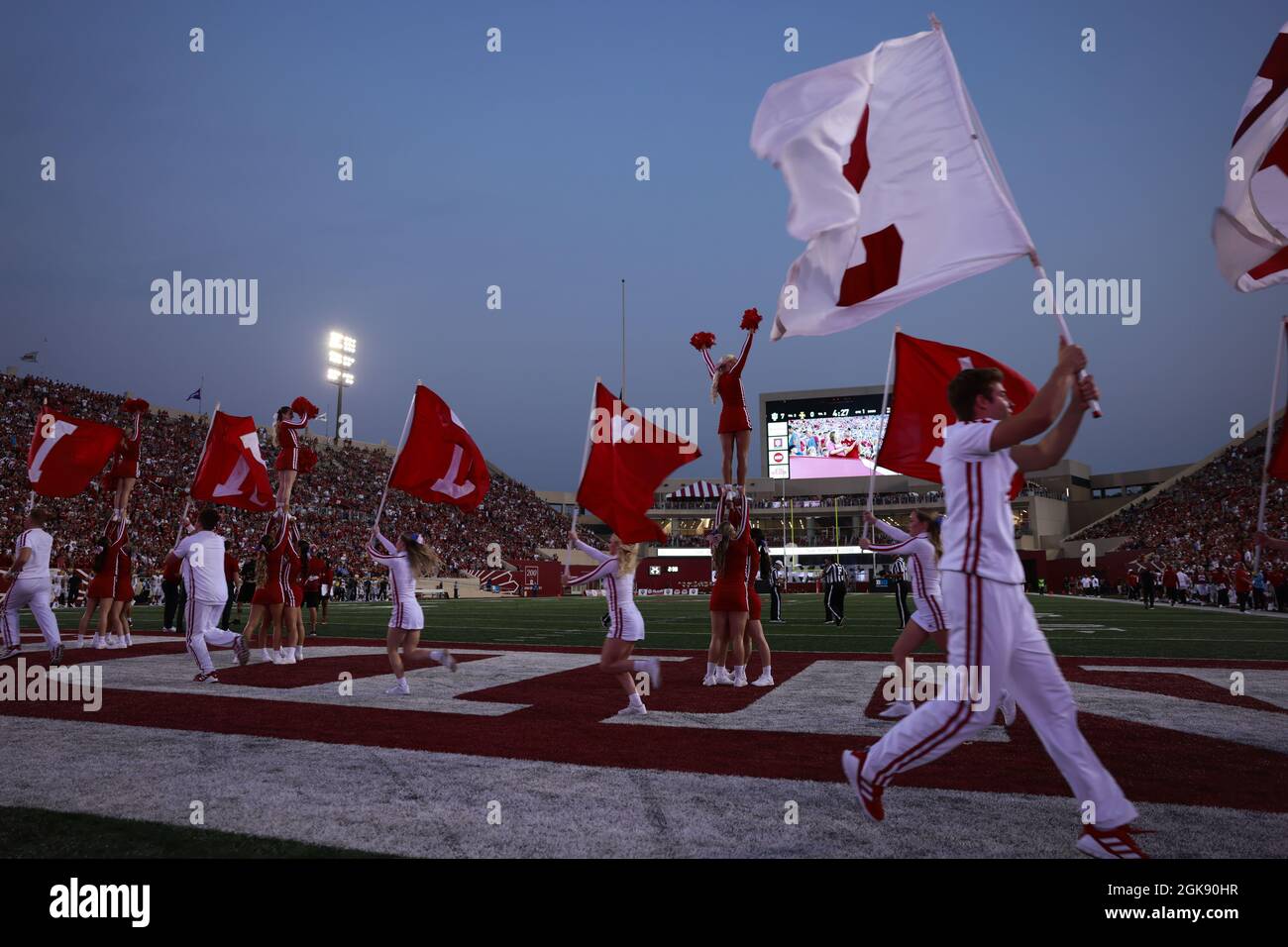 Indiana University cheerleaders carry flags after IU scores against Idaho during the NCAA football game at Memorial Stadium in Bloomington.The Hoosiers beat the Vandals 56-14. Stock Photo