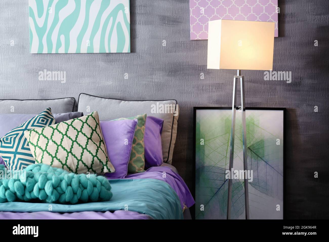 Lilac accent in modern interior. Comfortable bed with pillows and plaid in room Stock Photo Alamy