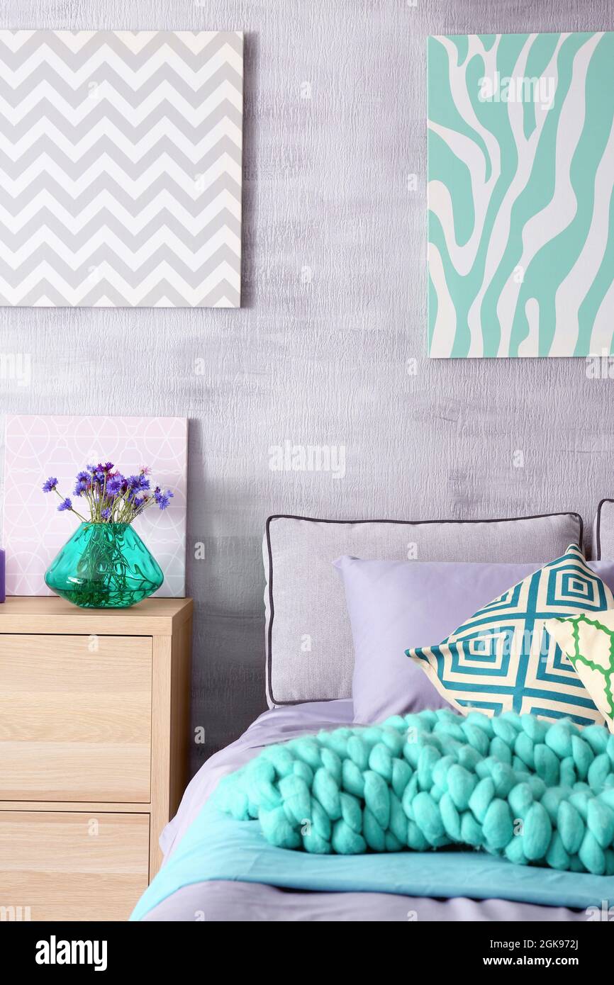 Lilac accent in modern interior. Comfortable bed with pillows and plaid in room Stock Photo Alamy