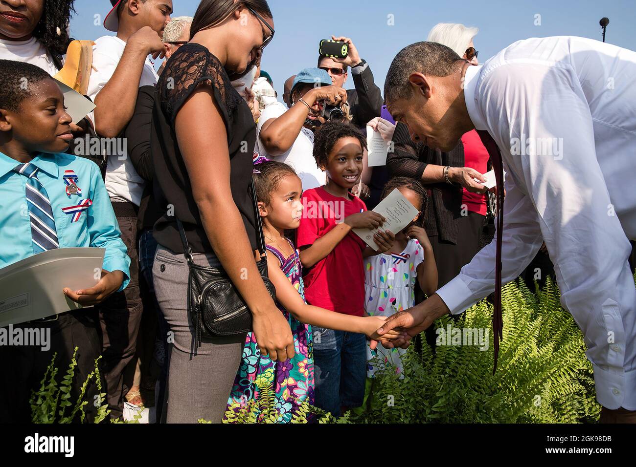 President Barack Obama greets children at the September 11th Observance Ceremony at the Pentagon Memorial in Arlington, Va., Sept. 11, 2013. (Official White House Photo by Pete Souza) This official White House photograph is being made available only for publication by news organizations and/or for personal use printing by the subject(s) of the photograph. The photograph may not be manipulated in any way and may not be used in commercial or political materials, advertisements, emails, products, promotions that in any way suggests approval or endorsement of the President, the First Family, or th Stock Photo