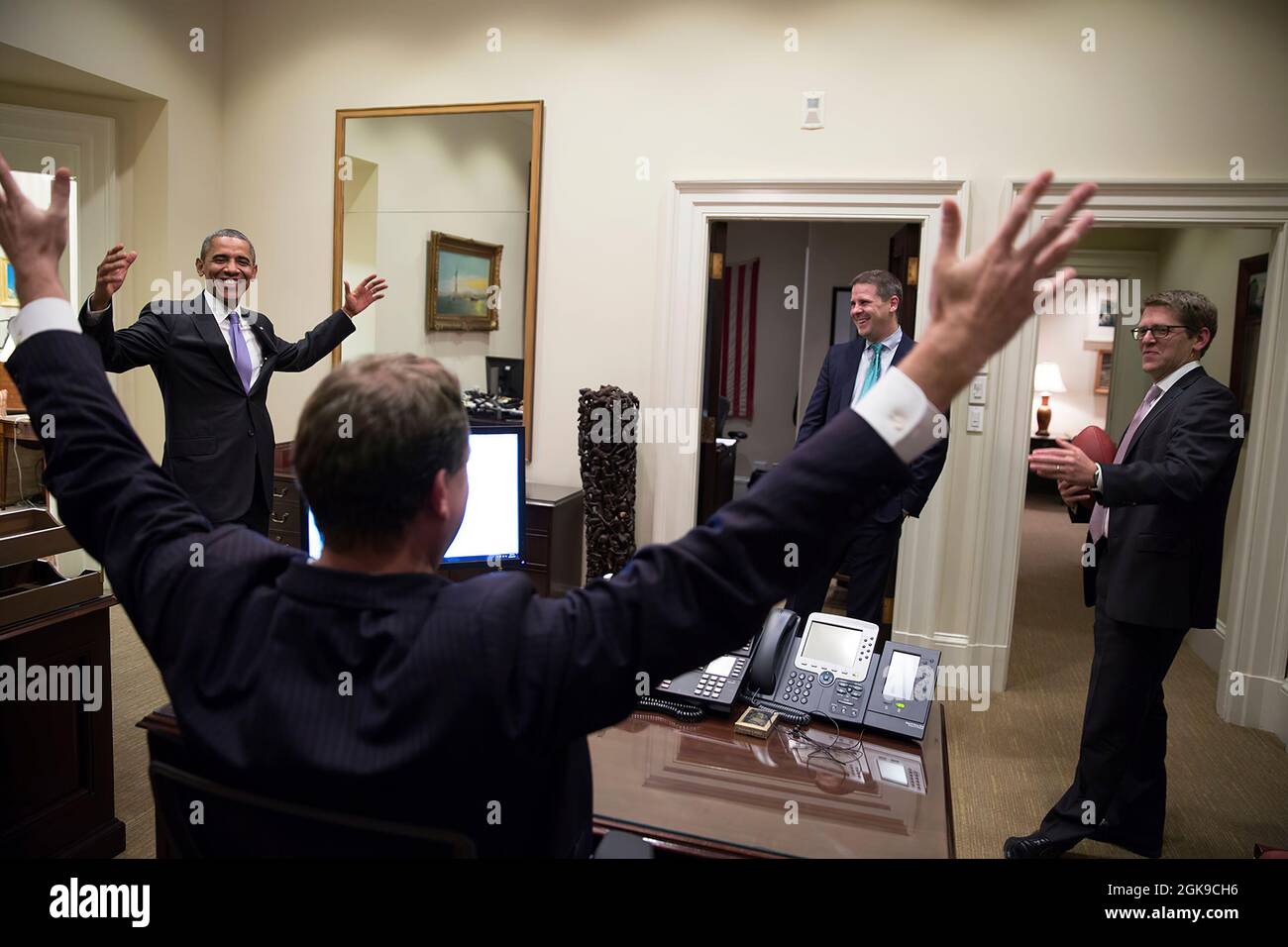 President Barack Obama tosses a football with Press Secretary Jay Carney in the Outer Oval Office, following the Senate vote on the federal government shutdown and debt ceiling, Oct. 16, 2013. Trip Director Marvin Nicholson and Senior Advisor Dan Pfeiffer watch. (Official White House Photo by Pete Souza)  This official White House photograph is being made available only for publication by news organizations and/or for personal use printing by the subject(s) of the photograph. The photograph may not be manipulated in any way and may not be used in commercial or political materials, advertisemen Stock Photo