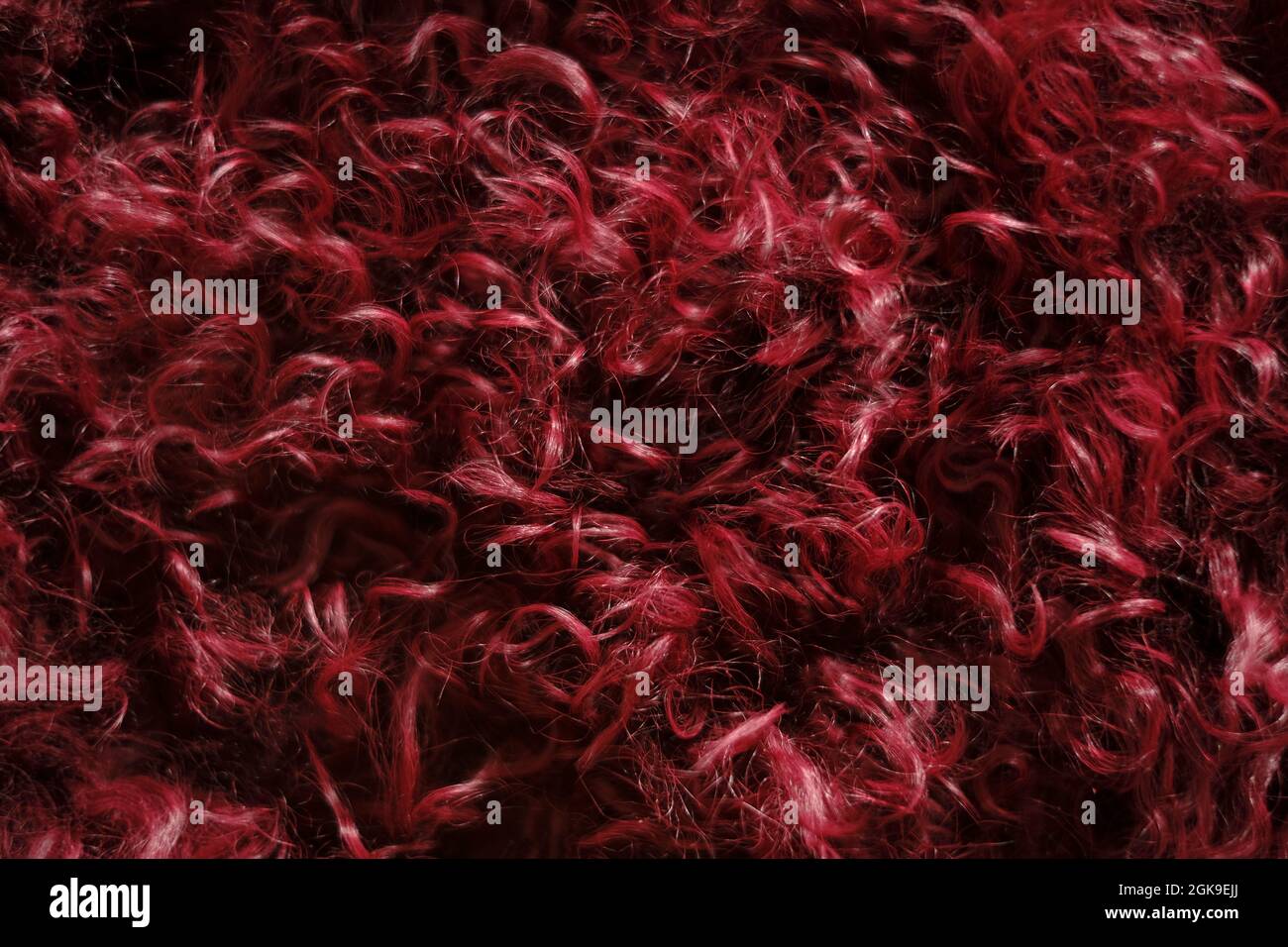 Fur background. Fluffy burgundy fur texture. real wool. Fur texture. Goat fur surface. Warm fluffy fur texture. Stock Photo