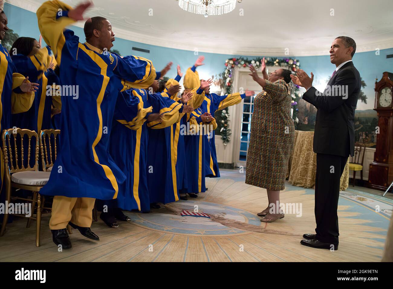 President Barack Obama listens to the Crenshaw Elite Choir perform in the Diplomatic Reception Room of the White House following a Christmas holiday reception, Dec. 11, 2013.  (Official White House Photo by Pete Souza) This official White House photograph is being made available only for publication by news organizations and/or for personal use printing by the subject(s) of the photograph. The photograph may not be manipulated in any way and may not be used in commercial or political materials, advertisements, emails, products, promotions that in any way suggests approval or endorsement of the Stock Photo
