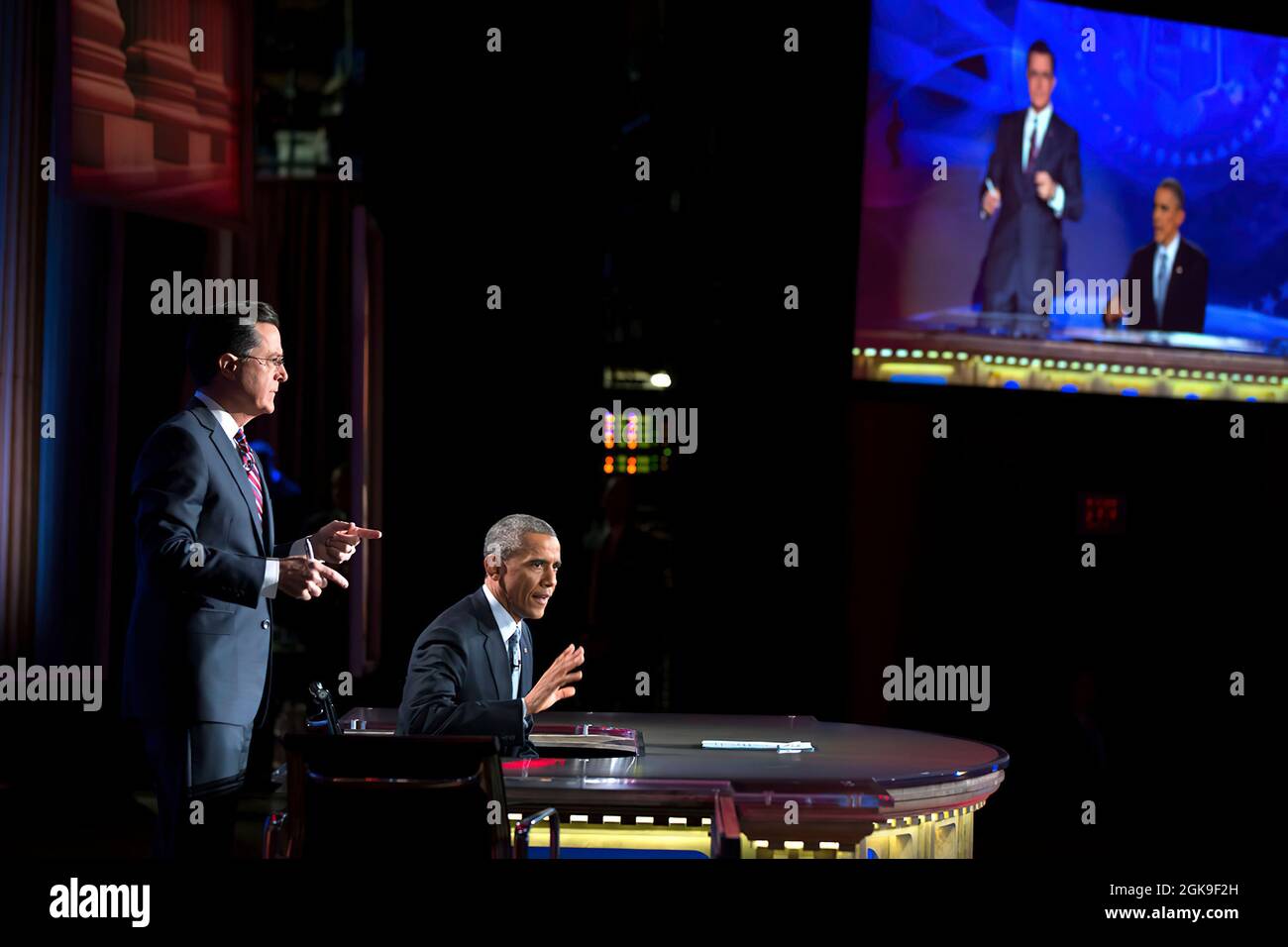 President Barack Obama takes over for Stephen Colbert during 'The Word' segment of 'The Colbert Report with Stephen Colbert' during a taping at George Washington University's Lisner Auditorium in Washington, D.C., Dec. 8, 2014. (Official White House Photo by Pete Souza) This official White House photograph is being made available only for publication by news organizations and/or for personal use printing by the subject(s) of the photograph. The photograph may not be manipulated in any way and may not be used in commercial or political materials, advertisements, emails, products, promotions tha Stock Photo