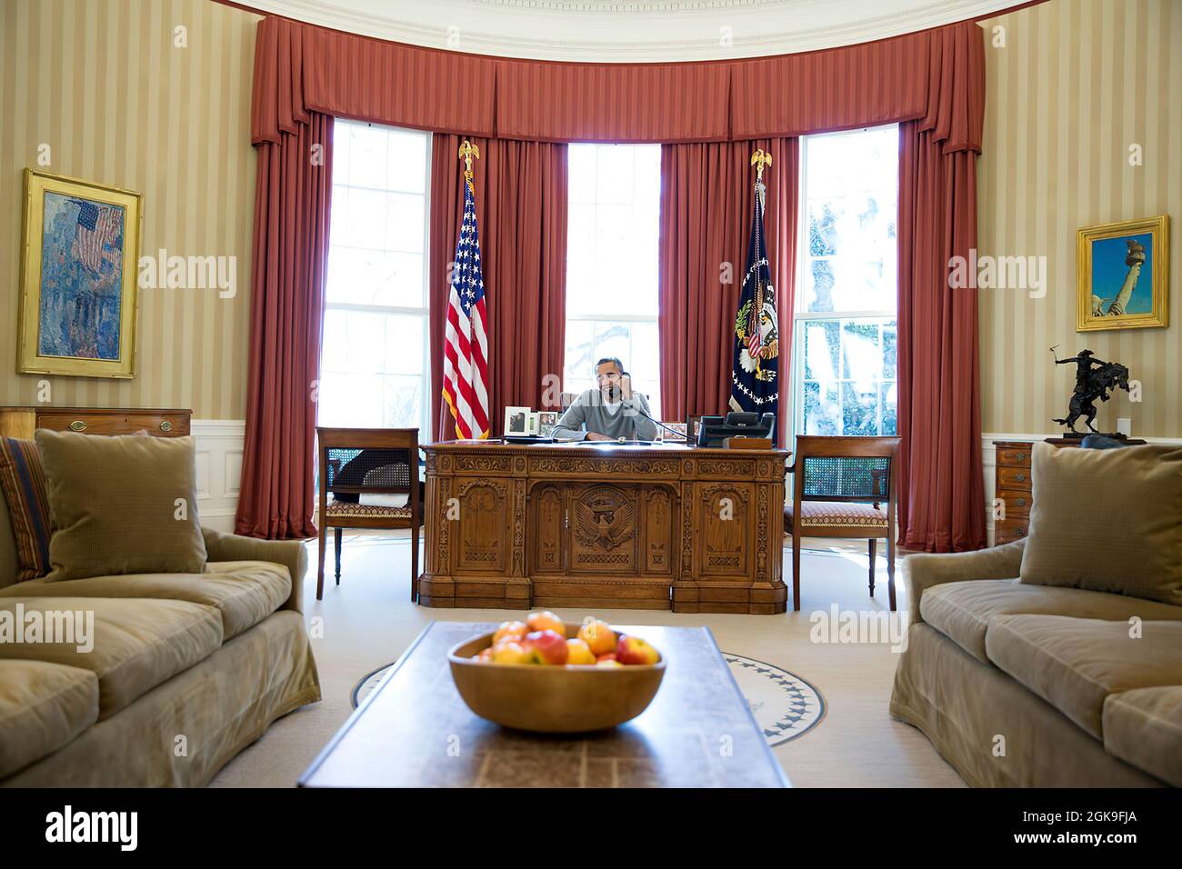 President Barack Obama makes Thanksgiving Day phone calls to U.S. troops from the Oval Office, Nov. 28, 2013.  (Official White House Photo by Pete Souza) This official White House photograph is being made available only for publication by news organizations and/or for personal use printing by the subject(s) of the photograph. The photograph may not be manipulated in any way and may not be used in commercial or political materials, advertisements, emails, products, promotions that in any way suggests approval or endorsement of the President, the First Family, or the White House. Stock Photo