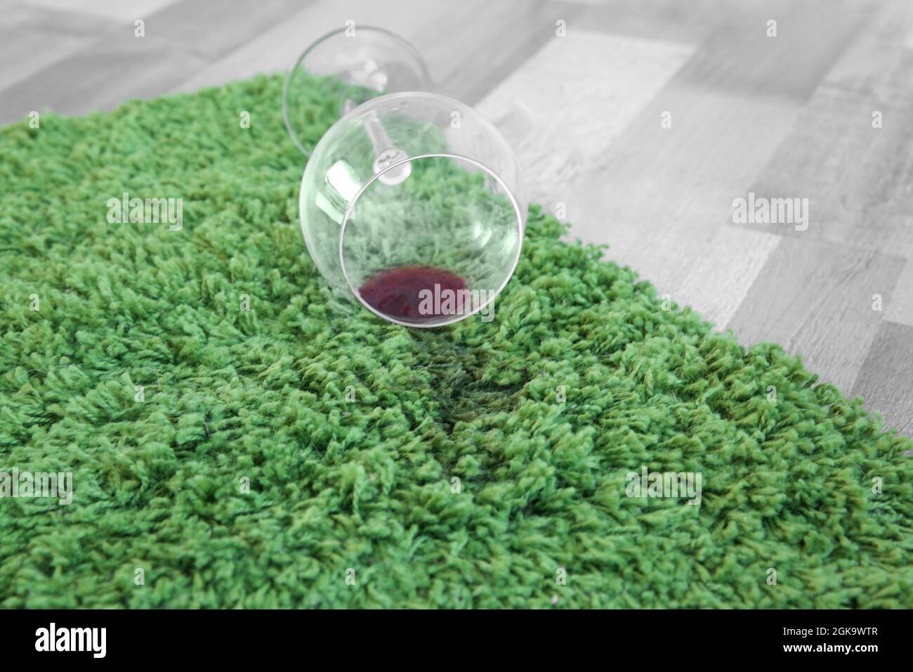 Glass of red wine spilled on green carpet Stock Photo Alamy