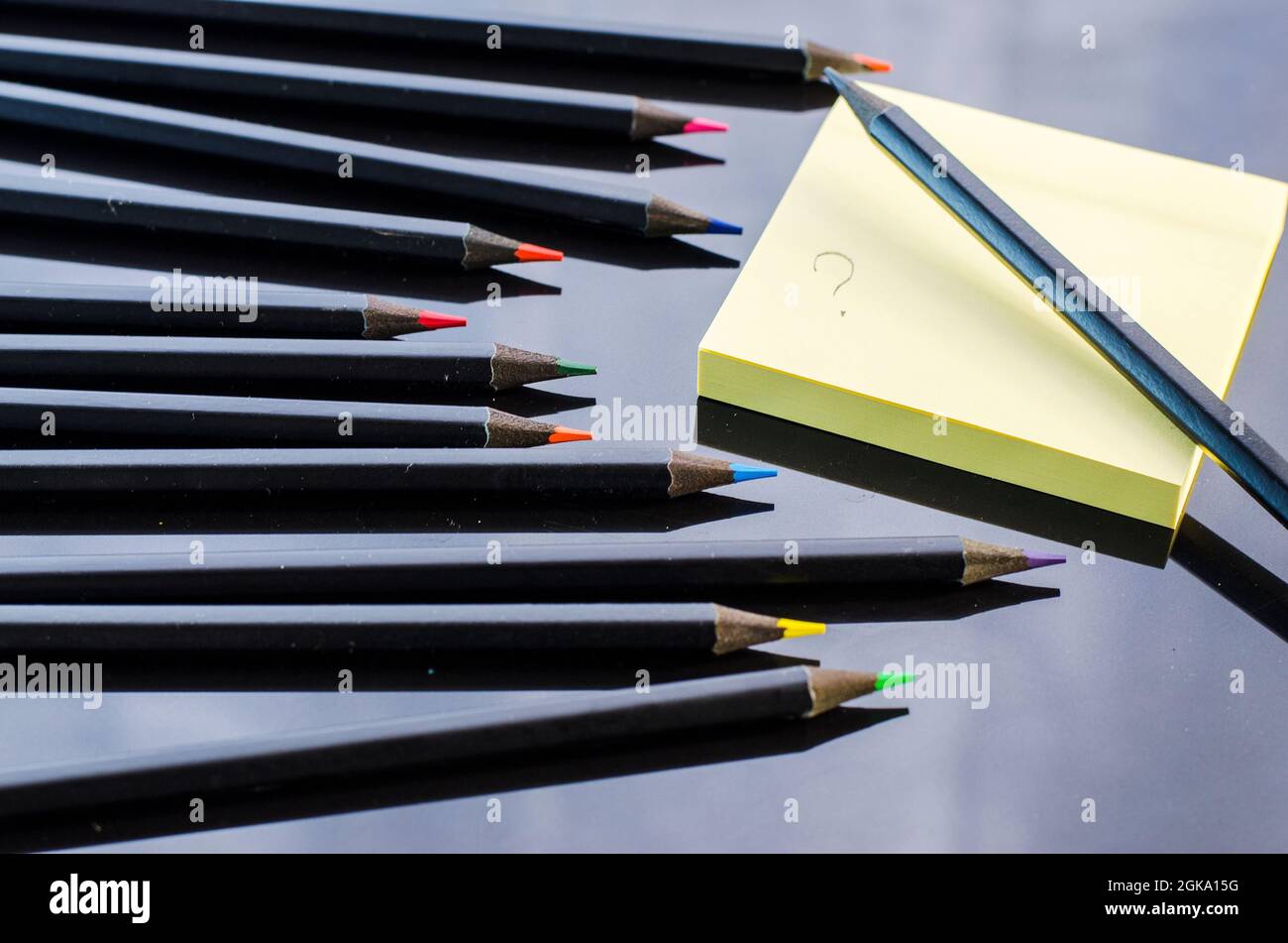 colored pencils and paper on a black background close Stock Photo