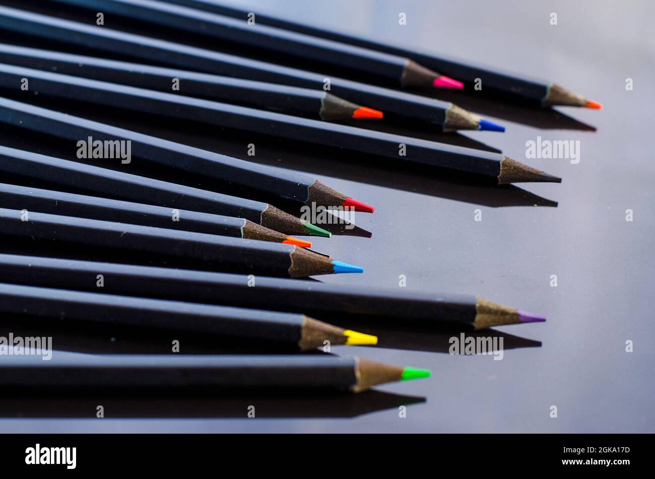 colored pencils and paper on a black background close Stock Photo