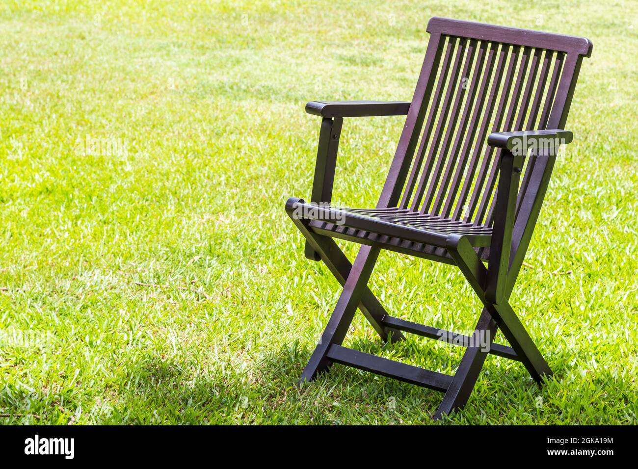 Black wooden chairs on the lawn green nature background Stock Photo - Alamy