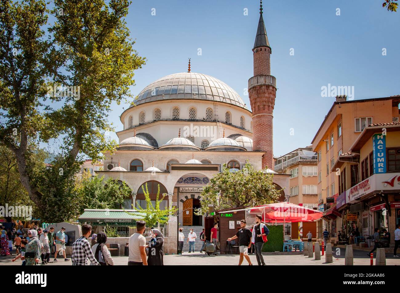 BURSA, TURKEY. AUGUST 15, 2021. Street view, Beautiful mosque on the square. Small shops and cafe around Stock Photo