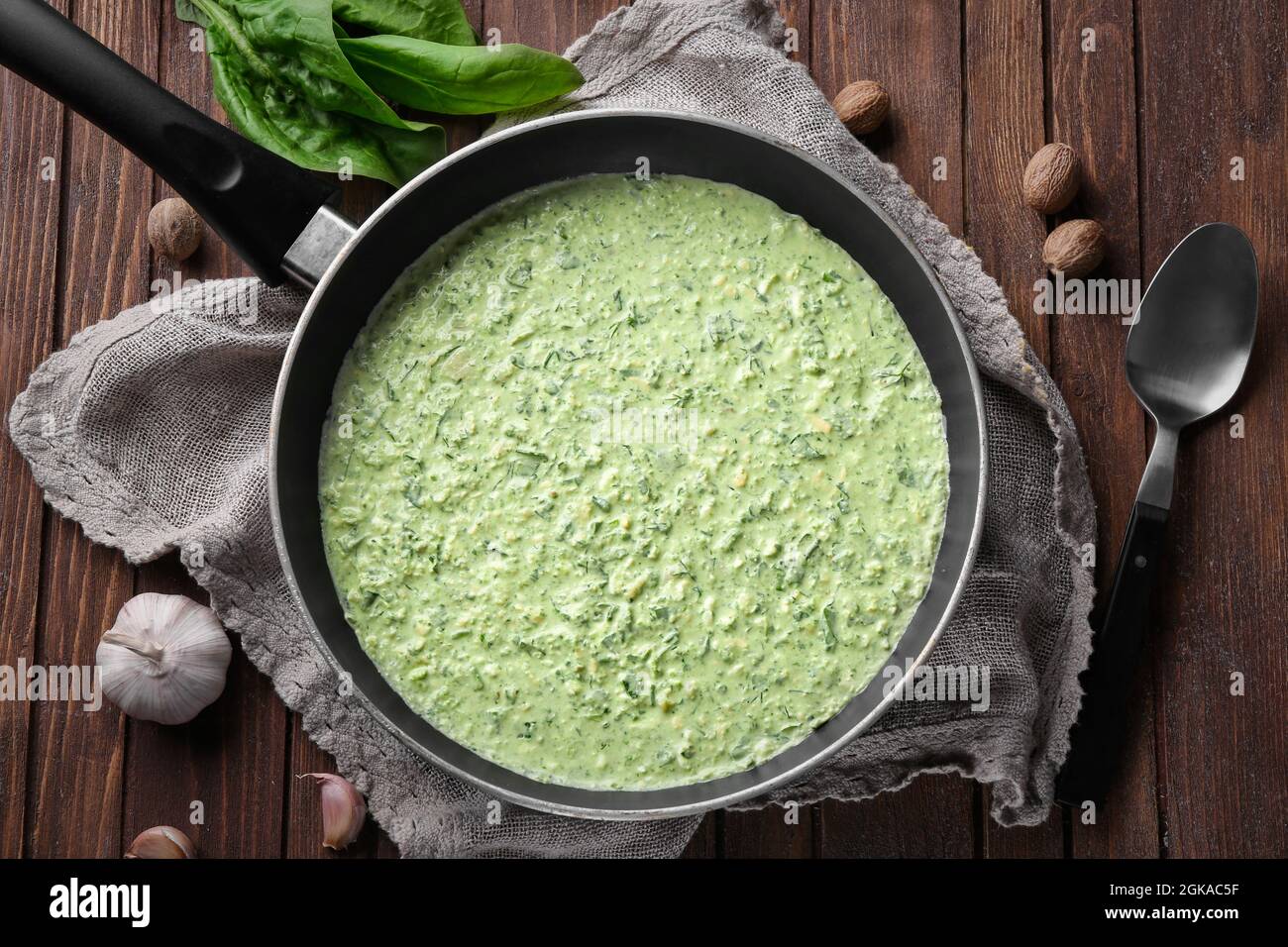Frying pan with tasty spinach sauce on table Stock Photo Alamy