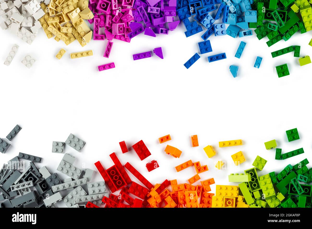 top view of border frame pile various colorful rainbow colored stackable plastic toy bricks isolated on white panorama background.. childhood educatio Stock Photo