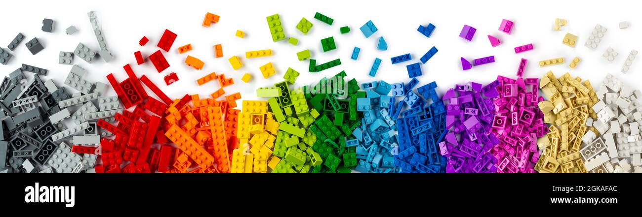 top view of wide pile various colorful rainbow colored stackable plastic toy bricks isolated on white panorama background.. childhood education constr Stock Photo