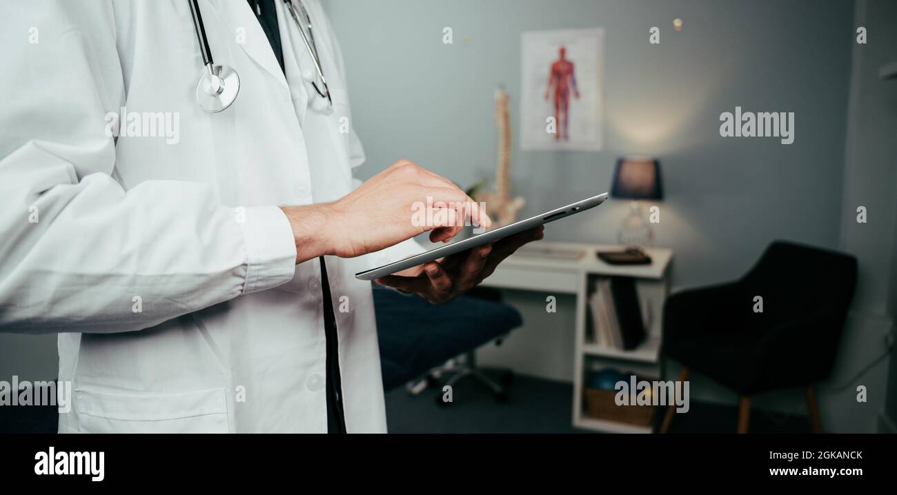 Close up male nurse typing on digital tablet Stock Photo