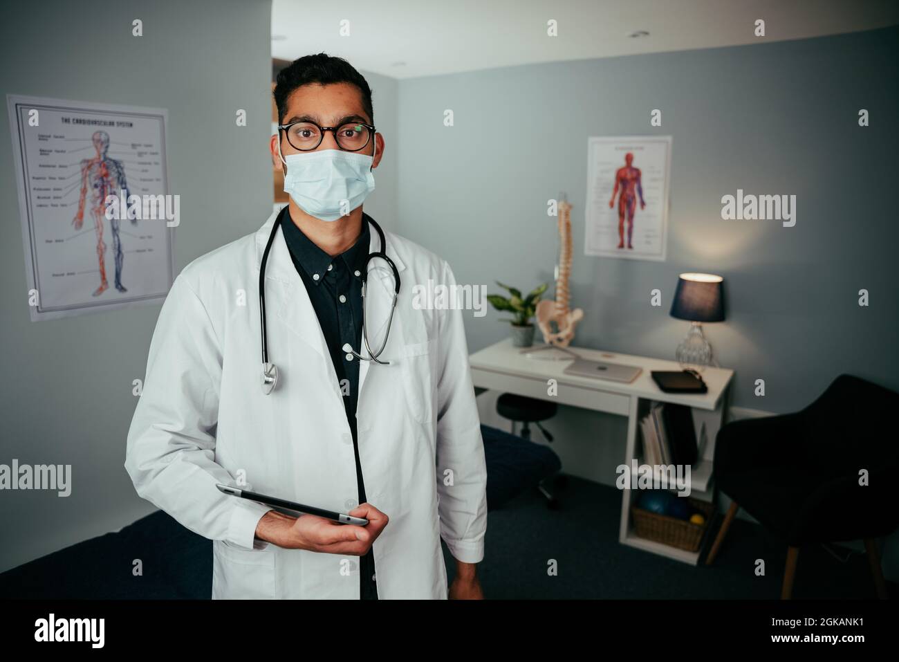 Caucasian male doctor working in office holding digital tablet Stock Photo
