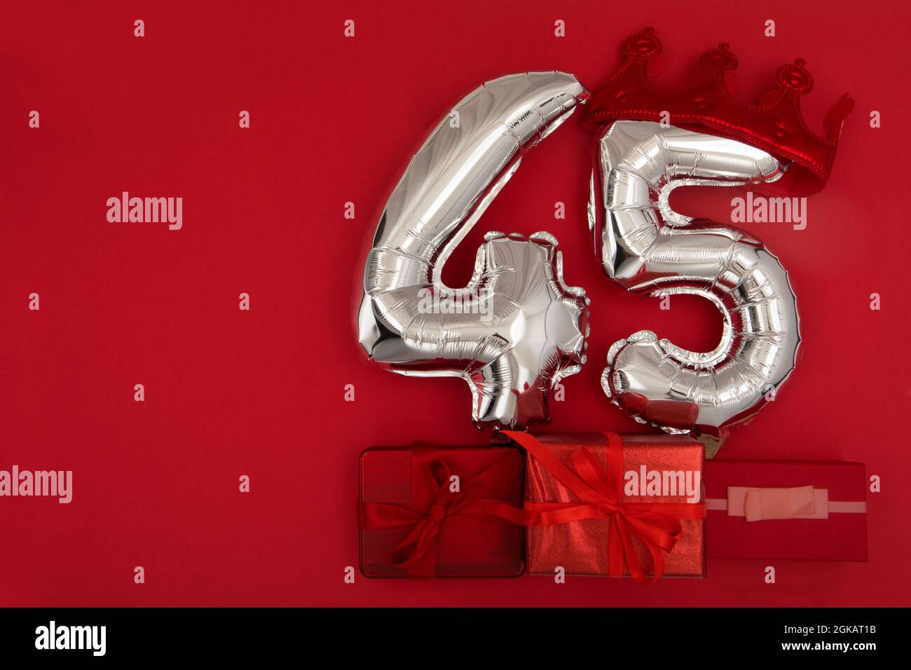 Silver Number Balloons 45 forty five in crown on dark red background. Holiday Party Decoration, 40 postcard concept with top view Stock Photo
