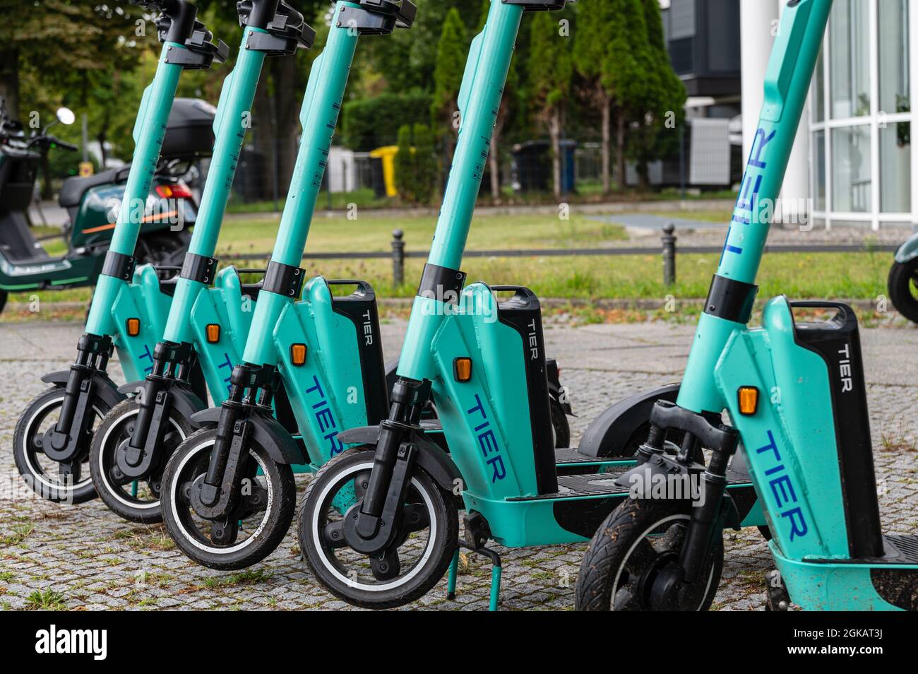 Row of five standing electric escooter or e-scooter of the company TIER on the sidewalk in Berlin Stock Photo