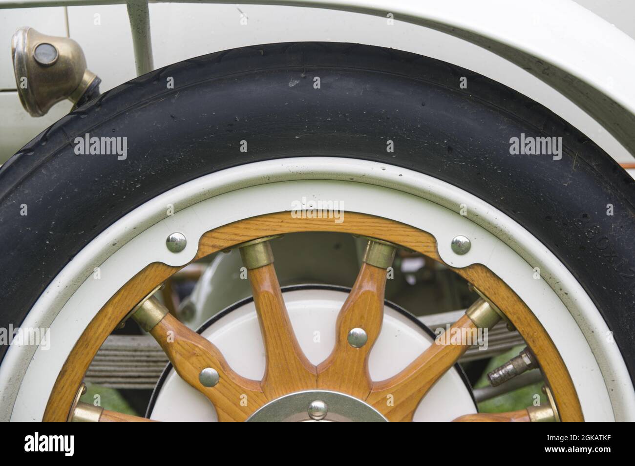 Close-up of tire and elegant refined wheel made of wooden and steel in white colour. Part of white gold antique retro vintage classic sport renovated car 1914 on exhibition Stock Photo
