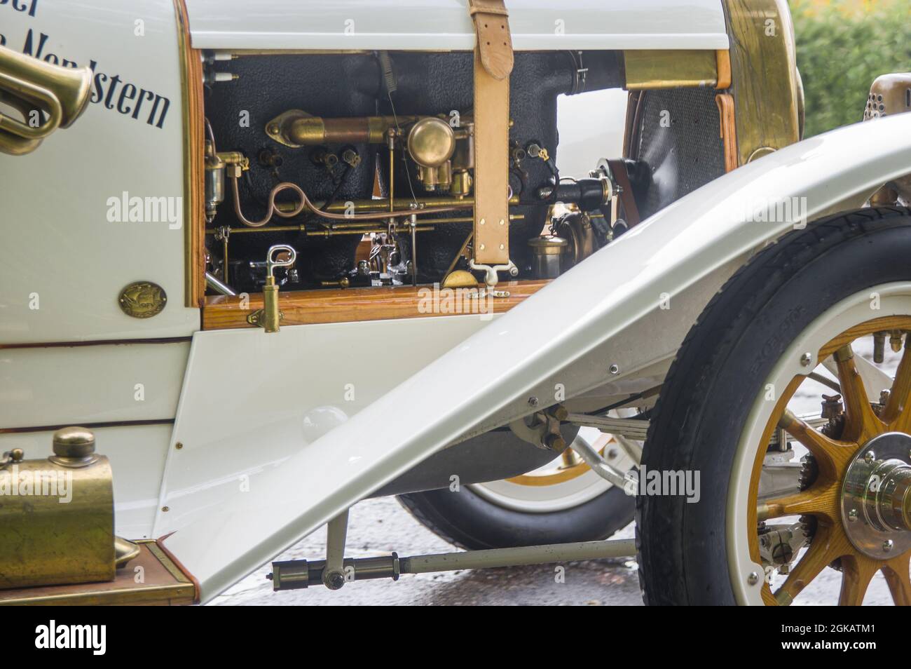 Close-up of elegant refined white gold antique retro sport renovated car 1914 on exhibition. Working attractive motor with different cylinders, tubules and leather straps of old vintage automobile Stock Photo
