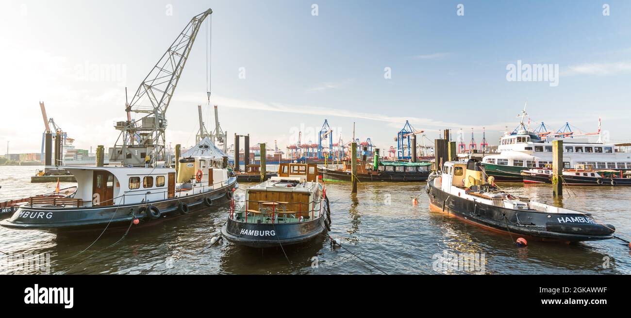 Historic boats and harbor cranes in the museum harbor in Hamburg Övelgönne in the morning sunlight Stock Photo