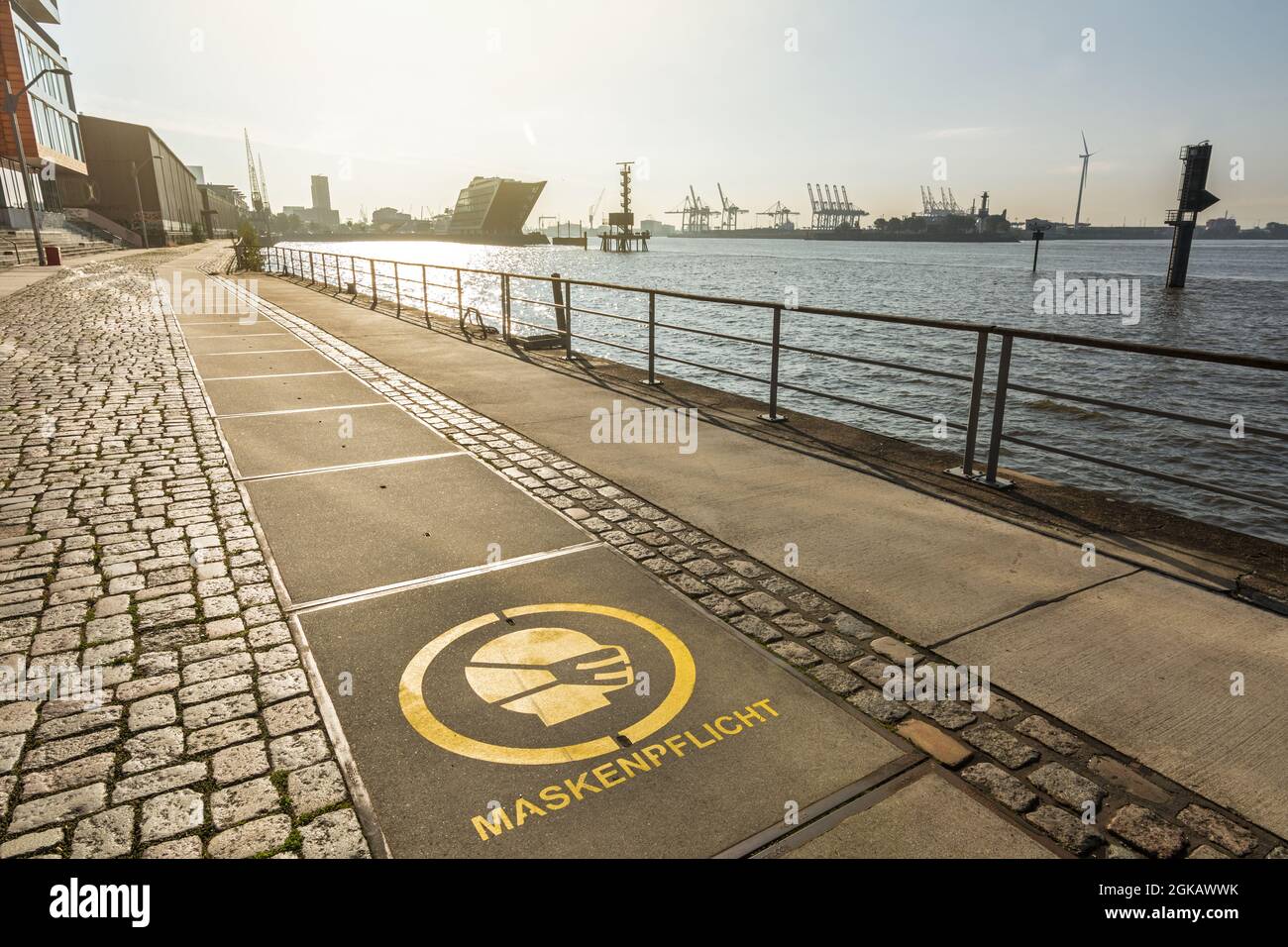 Waterfront of Övelgönne in Hamburg with ‘mask mandate’ sign in German language (Maskenpflicht) on the ground Stock Photo