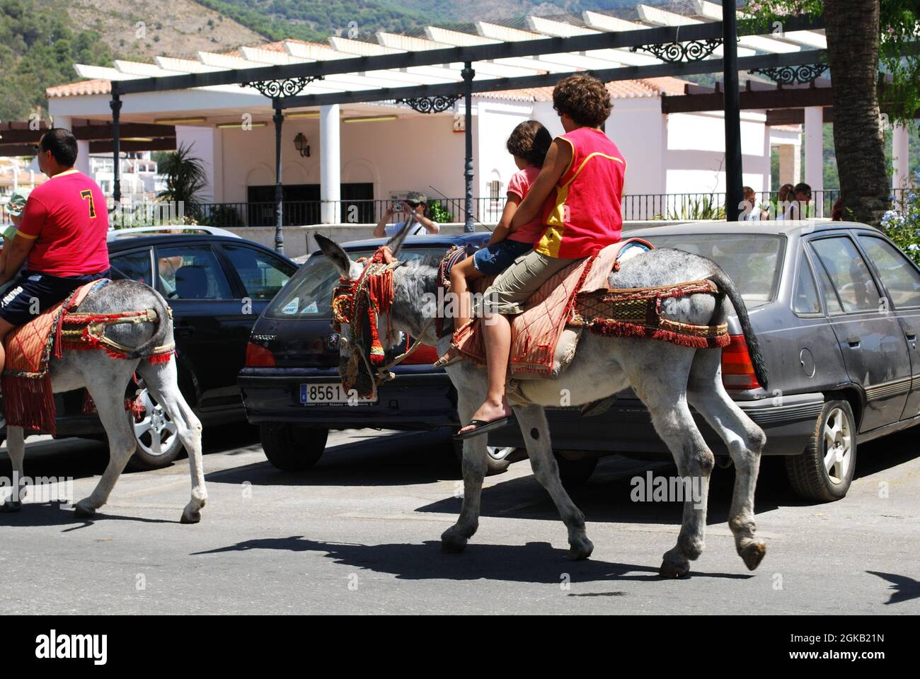 Child taking a donkey ride in the town centre, Burro Taxi, Mijas, Spain. Stock Photo