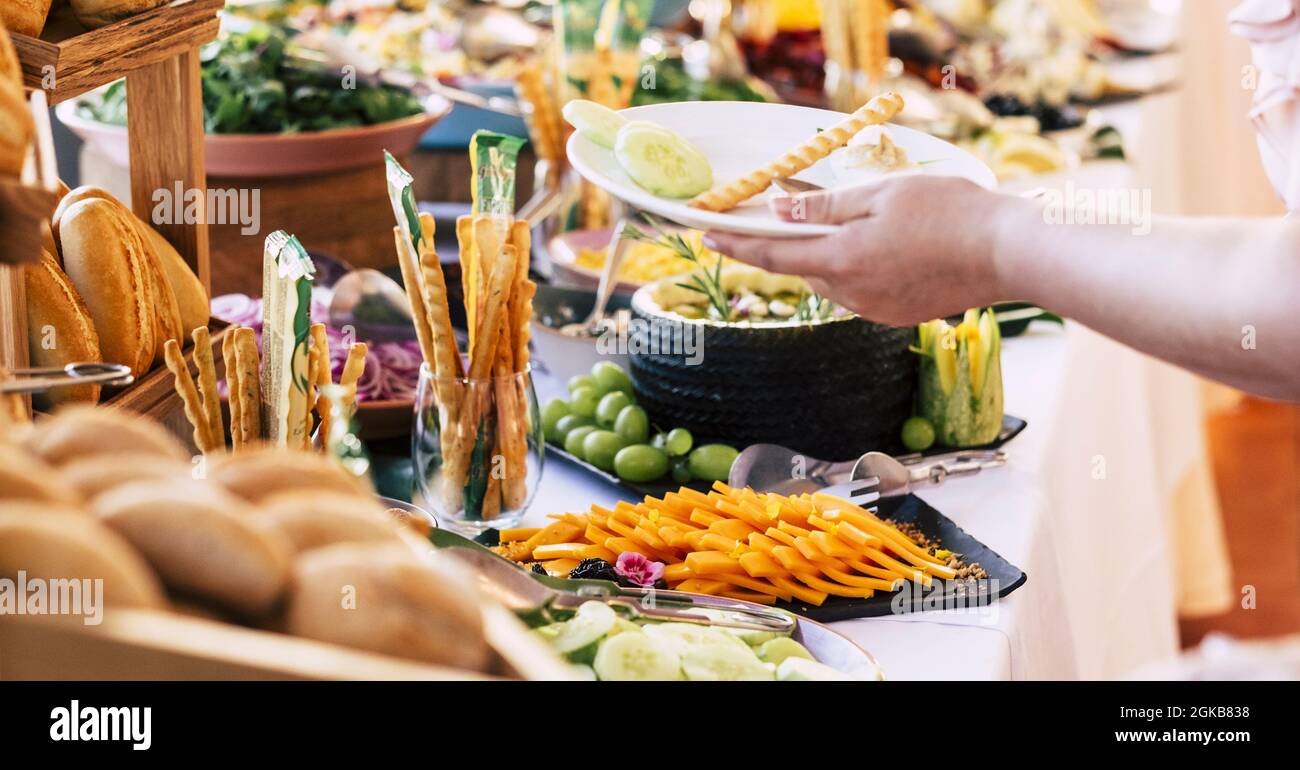 Unrecognised person serving food in plate with variety of breads on display  for buffet spread on table in luxury restaurant. Human hand serving food i  Stock Photo - Alamy