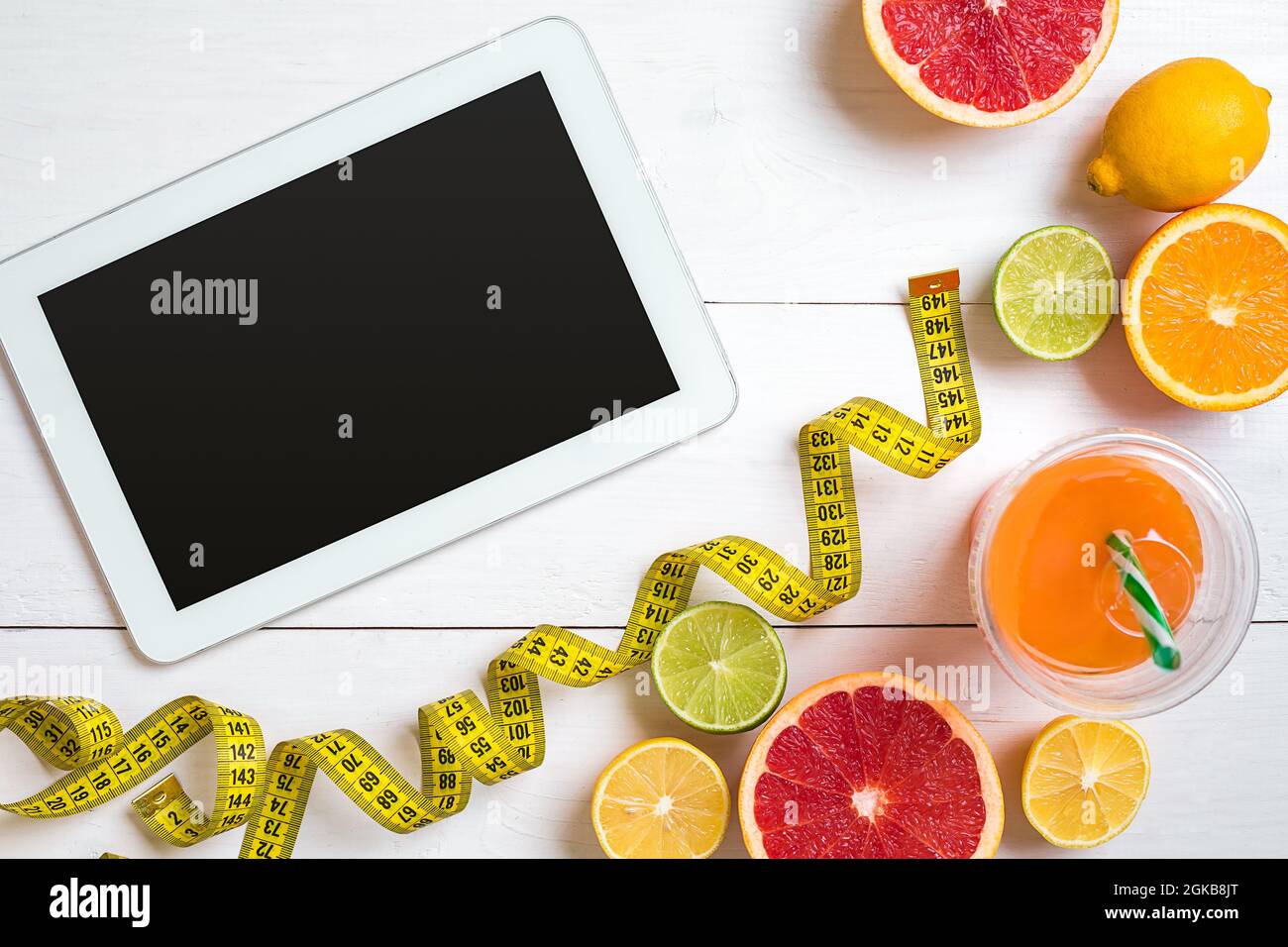 Fitness concept with fruit, a glass of juice and centimeter. Top view ...