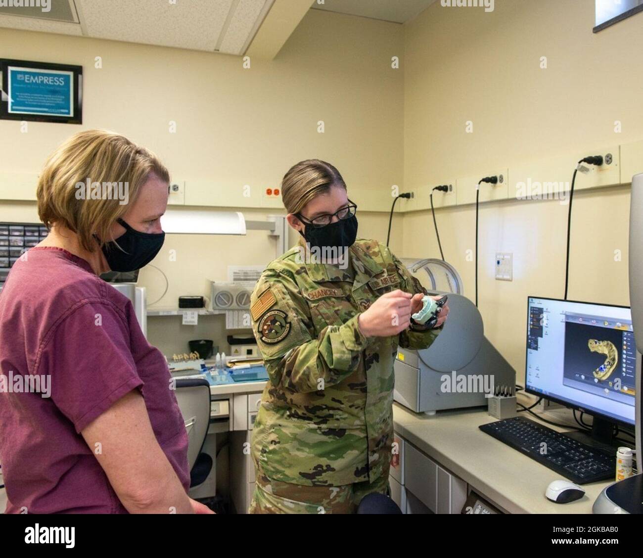 U.S. Air Force Staff Sgt. Aimee Chancey, right, a dental laboratory technician assigned to the 673d Dental Squadron, shows a model camera for crowns and implants to U.S. Air Force Col. Kirsten Aguilar, Joint Base Elmendorf-Richardson and 673d Air Base Wing commander, at JBER, Alaska, March 2, 2021. The tour familiarized base leadership with the 673d Dental Squadron and its role in supporting readiness. The 673d Dental Squadron provides a full range of dental care to active-duty Air Force, eligible active-duty mission partners, sister services, and foreign military members. Stock Photo