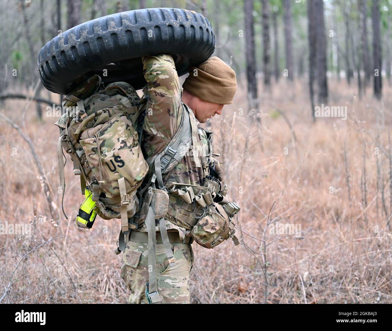 A Civil Affairs candidate at the U.S. Army John F. Kennedy Special Warfare Center and School carries a tire while participating in a team-building event during Civil Affairs Assessment and Selection (CAAS) at Camp Mackall, North Carolina, March 2, 2021. The candidates who attended the 10-day course were evaluated for trainability and suitability to attend the Civil Affairs Team Leader or the Civil Affairs Noncommissioned Officer pathway and for the attributes and competencies required to be a member of a Civil Affairs Team. Stock Photo