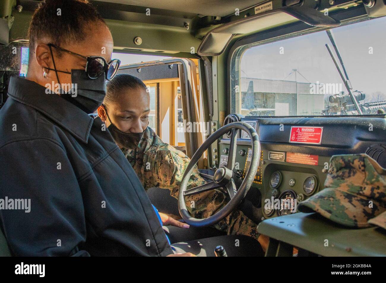 U.S. Marine Corps Gunnery Sgt. Lakiesha Harris, a motor transportation sergeant with the Marietta-based Combat Logistics Regiment 45, teach a Leadership Cobb participant basics operating a M1151A1 Humvee March 3, 2021, at Dobbins Air Reserve Base, Marietta, Georgia. The Georgia Department of Defense and U.S. Air Force Reserve's 94th Airlift Wing hosted Leadership Cobb for an event to promote partnership and leadership. Stock Photo