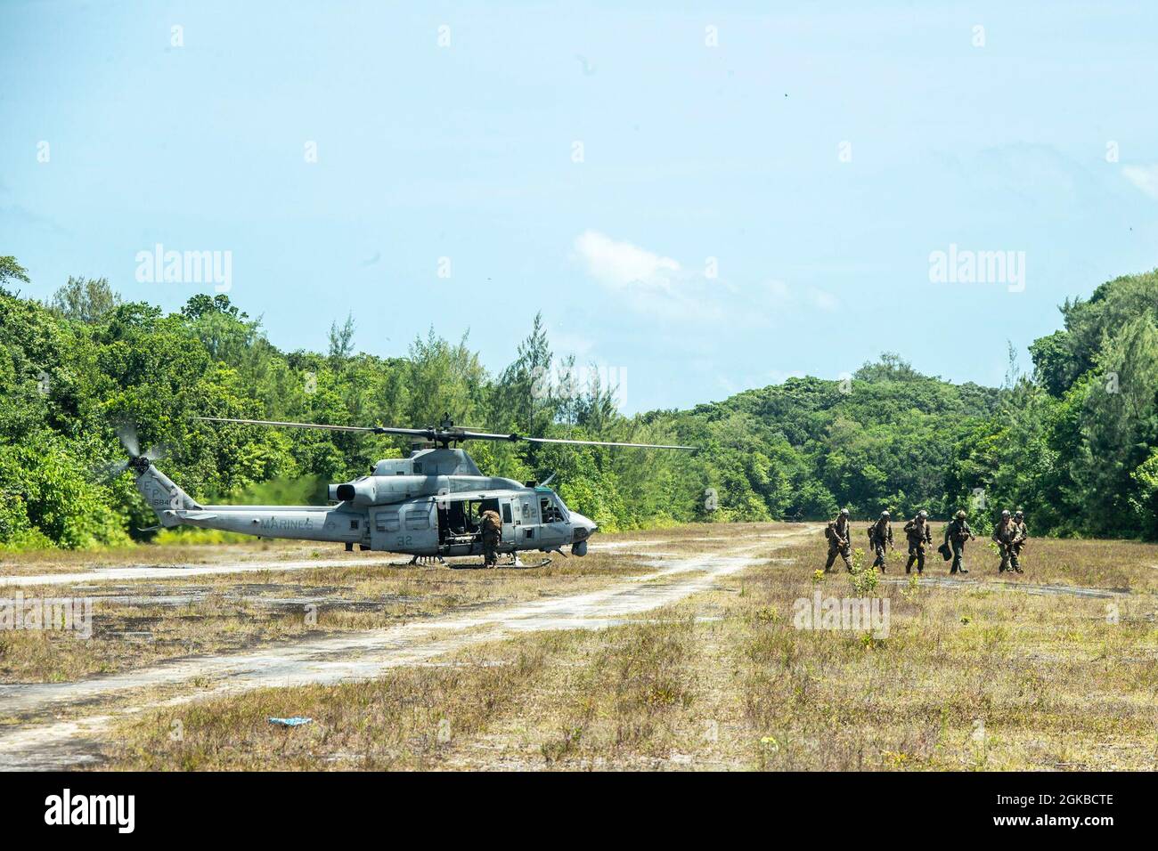 U.S. Marines exit a UH-1Y Huey with Marine Medium Tiltrotor Squadron 262 (Reinforced), after landing on the island of Peleliu, Republic of Palau, March 3, 2021. The 31st MEU is operating aboard ships of the Amphibious Squadron 11 in the 7th fleet area of operations to enhance interoperability with allies and partners and serve as a ready response force to defend peace and stability in the Indo-Pacific region. Stock Photo