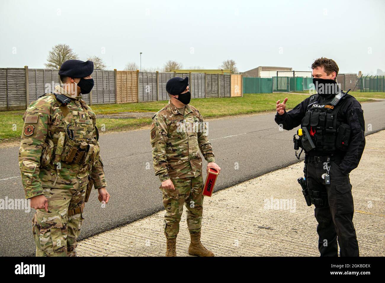 A policeman from the Northamptonshire Police Department, speaks with 1st Lt. George Marte, left, 422d Security Forces Squadron operations officer, and Staff Sgt. Alvaro Gonzalez, 422d SFS unit trainer, after a field training exercise at RAF Croughton, England, Mar. 3, 2021.  The NHPD utilized the 422d SFS training complex to help strengthen their tactics and techniques. Events like this help strengthen the local partnership between the 422d SFS and the NHPD. Stock Photo