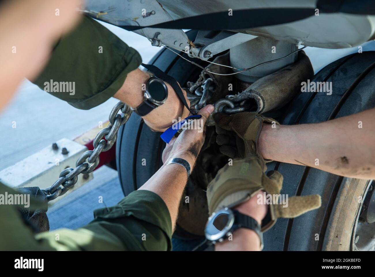 U.S. Marines with Marine Heavy Helicopter Squadron 463 hook up a chain to a CH53E Super