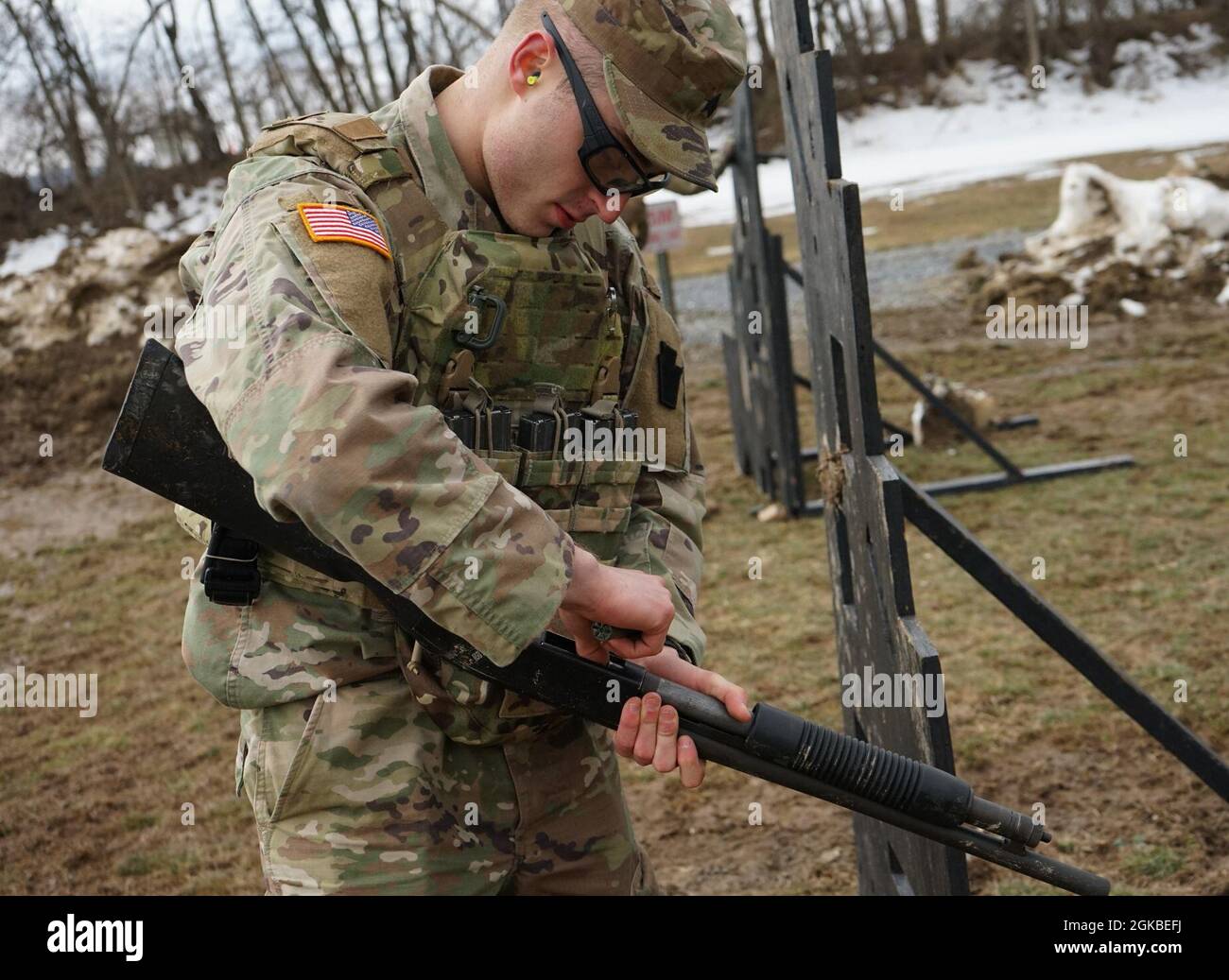 Sgt. Alexander Heber, a Soldier from the 56th Stryker Brigade Combat Team, 28th Infantry Division, loads a 12-gauge shotgun shell into the M500 shotgun during M500 shotgun qualifications part of the Pennsylvania Army National Guard's Best Warrior Competition on March 4, 2021, at Fort Indiantown Gap, Pa. The range portion of the competition consisted of qualification with the M4 carbine, M17 pistol, and M500 shotgun. Stock Photo