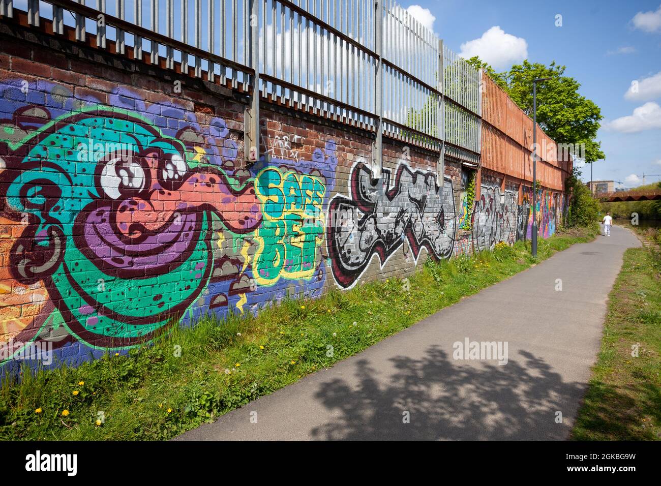 View of the Trans Pennine Trail near Leeds, with graffiti on a wall next to the path Stock Photo